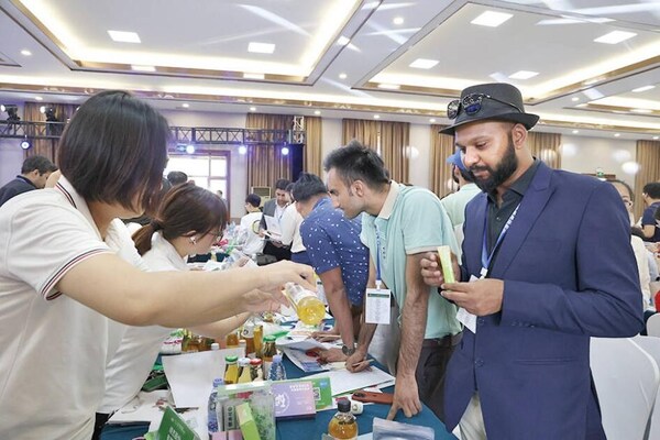 Photo shows that a Pakistani merchant tasted apple vinegar at an exhibition stand during the international procurement event held in Longkou City of east China's Shandong Province recently. (Source: Longkou/Liu Qiqiang)