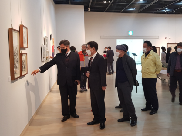 이승옥 군수가 아트페어에서 작가들의 작품을 감상하고 있다.