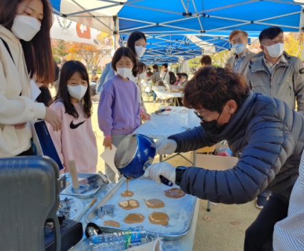 주민들이 지난 7일 화랑공원에서 열린 ‘코로나19 이겨내고 책・음악과 마주하다’ 마을 축제에 참여해 달고나 만들기 체험을 하고 있다.
