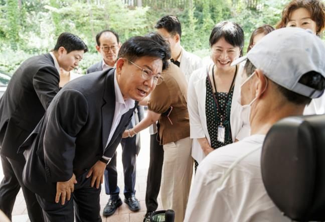 박강수 마포구청장이 휠체어를 탄 어르신의 안부를 살피고 있다.