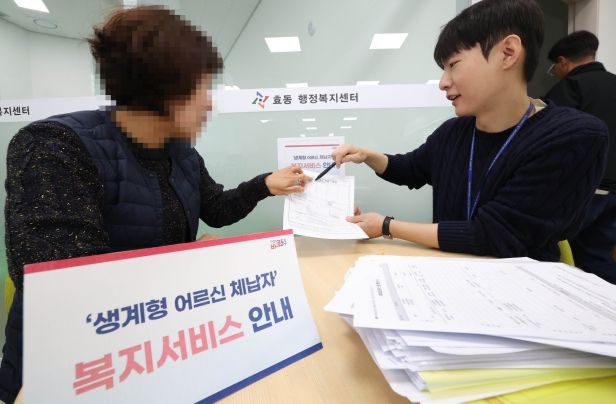 효동 행정복지센터 복지담당 직원이 주민에게 복지서비스를 안내하고 있는 모습