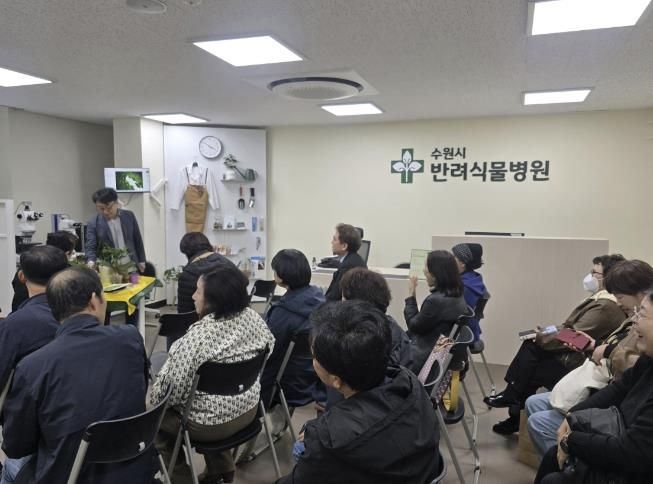 반려식물병원에서 열린 ‘집단 진료의 날’ 행사에서 전문가가 식물 관리 요령을 설명하고 있다.