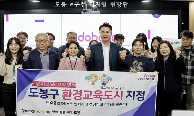 오언석 도봉구청장(가운데)이 환경교육도시 2회 연속 지정을 기념하며 직원들과 단체 사진을 찍고 있다