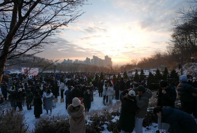 2024년 강북 해맞이 행사에 참여한 구민들이 새해 첫 해를 사진으로 담고 있다.