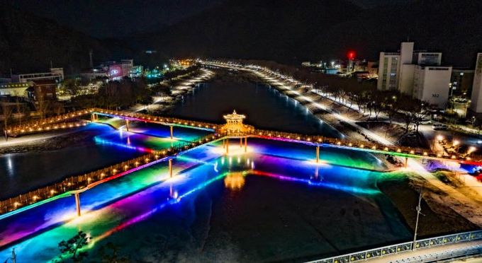 한파로 얼어붙은 괴산군 성황천과 동진천 위로 두 하천을 잇는 에코브릿지의 다채로운 색감의 경관조명이 얼음에 반영돼 겨울밤 수변의 이색적인 풍경을 연출하고 있다.