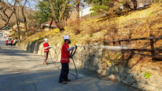 강북구 산림재난대응단이 산불지연제를 살포하고 있다.