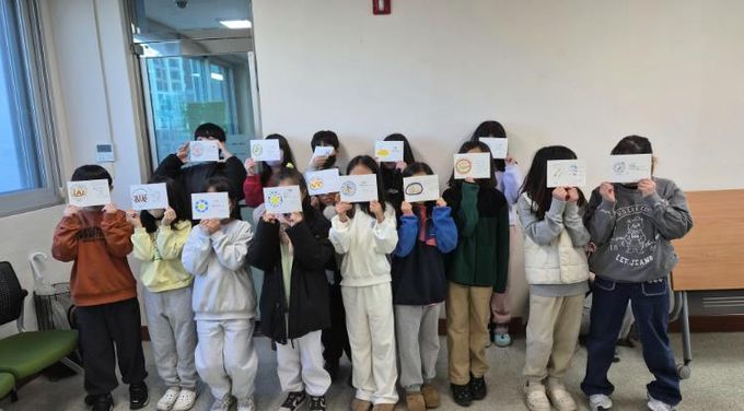 울산 초등학생들이 3일 울주도서관에서 '그림책 담은 멋 글씨 엽서' 활동을 하고 기념사진을 찍고있다