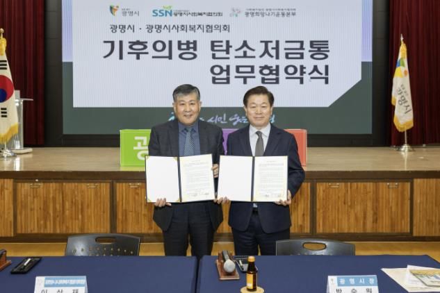 박승원 광명시장(사진 오른쪽)이 13일 오전 시청 대회의실에서 이상재 광명시사회복지협의회장(사진 왼쪽)과 ‘기후의병 탄소저금통 기부금 조성 협약’을 체결하고 기념사진을 촬영하고 있다.