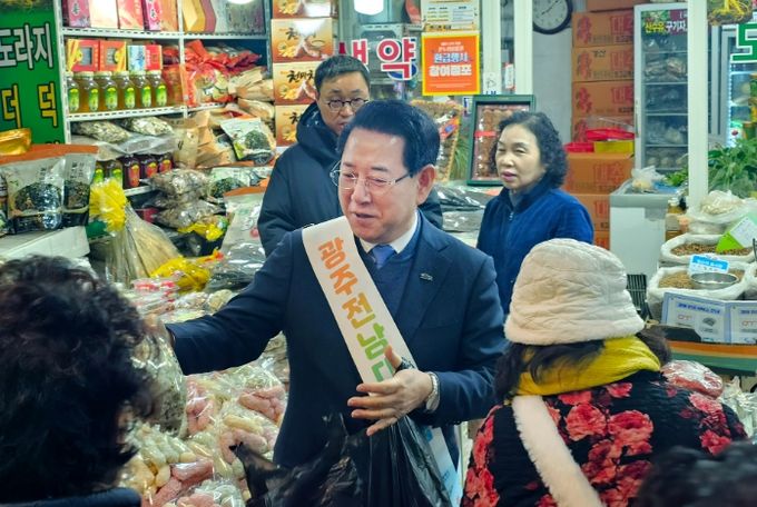 김영록 전남도지사가 설 명절을 앞둔 14일 광주 남광주시장에서 제수용품을 구매하며 상인들을 격려하고 있다.