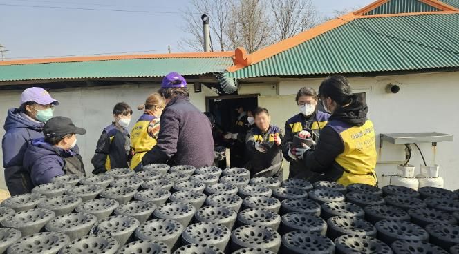 21일 봉사자들이 연탄을 트럭에 싣는 모습