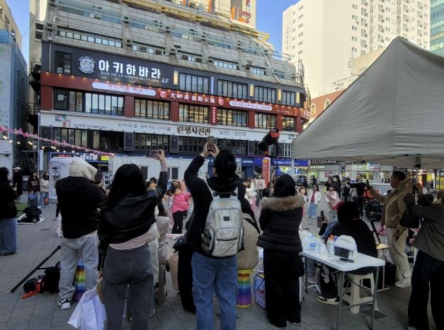 시민들이 인플루언서 크림서현과 랜덤댄스 챌린지 참여자들의 공연을 관람하고 있다.