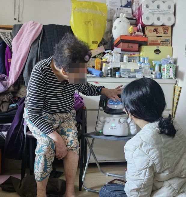 방문전문인력이 어르신 가정을 방문하여 AI돌봄로봇 활용교육을 실시하는 모습